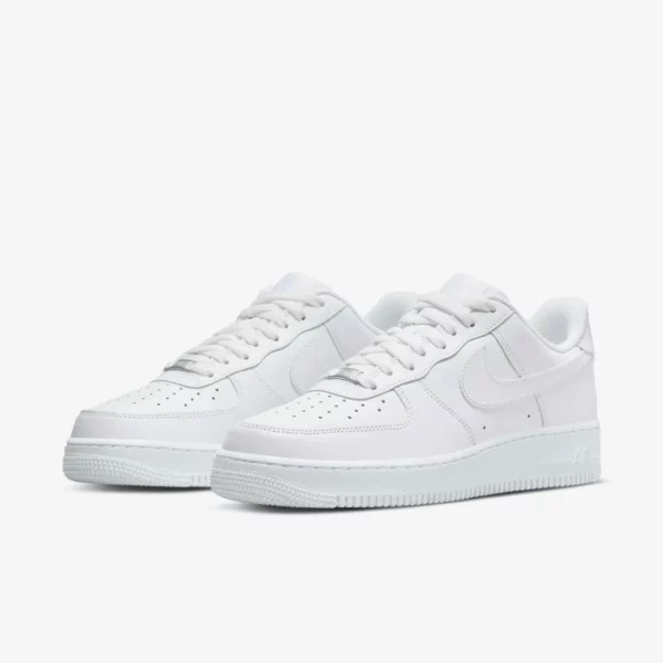 Baskets blanches en cuir, design bas, swoosh emblématique, perforations, semelle antidérapante, polyvalentes.
